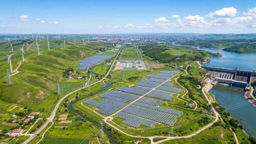 Aerial view of wind turbines, solar farms, and hydropower connected by power lines enabling the renewable grid.