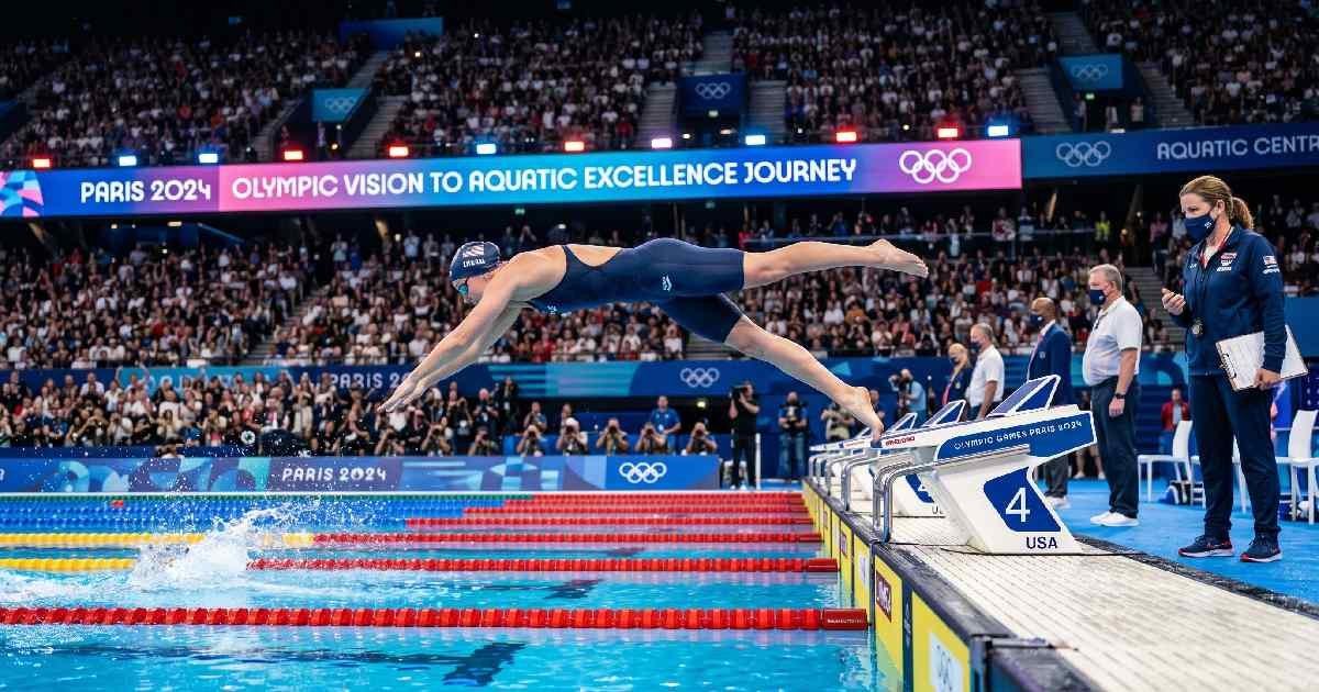 Determined Olympic swimmer diving into the competition pool, representing the journey from Olympic vision to aquatic excellence.