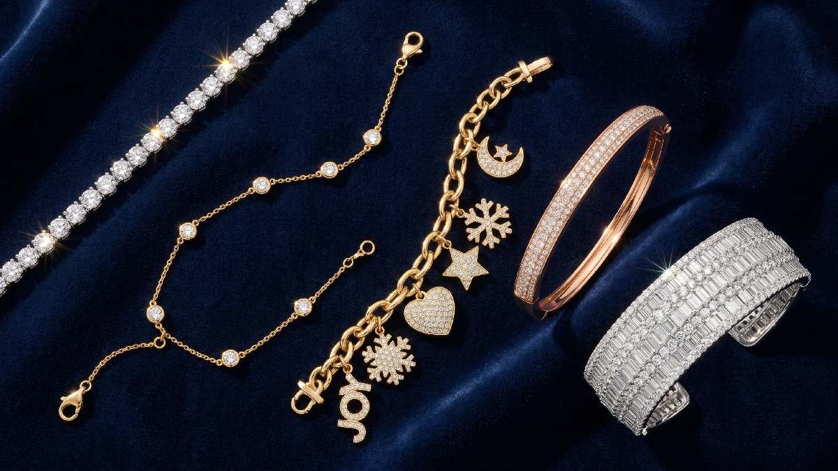  Five diamond bracelet styles including tennis, bangle, charm, chain, and cuff arranged on dark velvet surface.